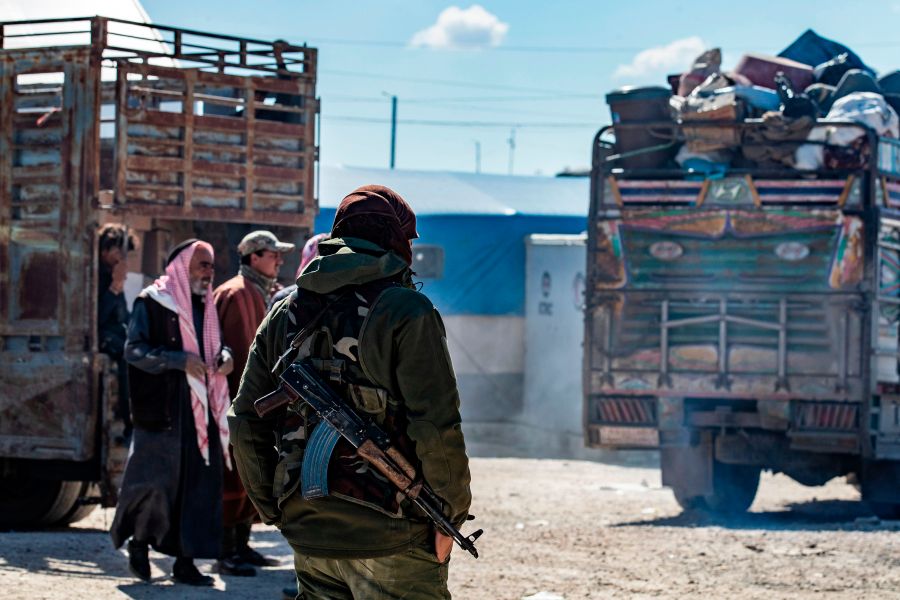 A member of Kurdish internal security stands guard during the release of another group of Syrian families from the Kurdish-run al-Hol camp which holds suspected relatives of Islamic State (IS) group fighters, in Hasakeh governorate of northeastern Syria, on Feb. 20, 2021. (Delil SOULEIMAN / AFP via Getty Images)