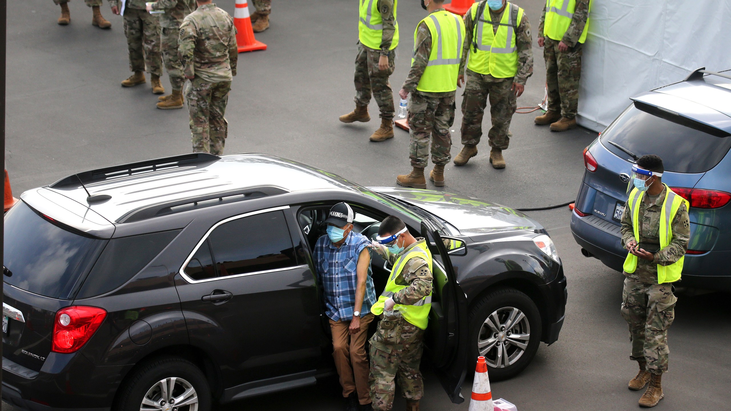 A person is vaccinated by a member of the National Guard at a new large scale COVID-19 vaccination site at Cal State Los Angeles on Feb. 16, 2021. (Mario Tama/Getty Images)