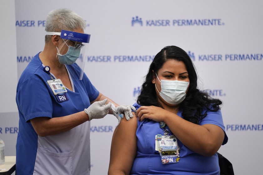 Nurse Helen Cordova, right, receives the Pfizer-BioNTech COVID-19 vaccine at Kaiser Permanente Los Angeles Medical Center. (Jae C. Hong / Associated Press )