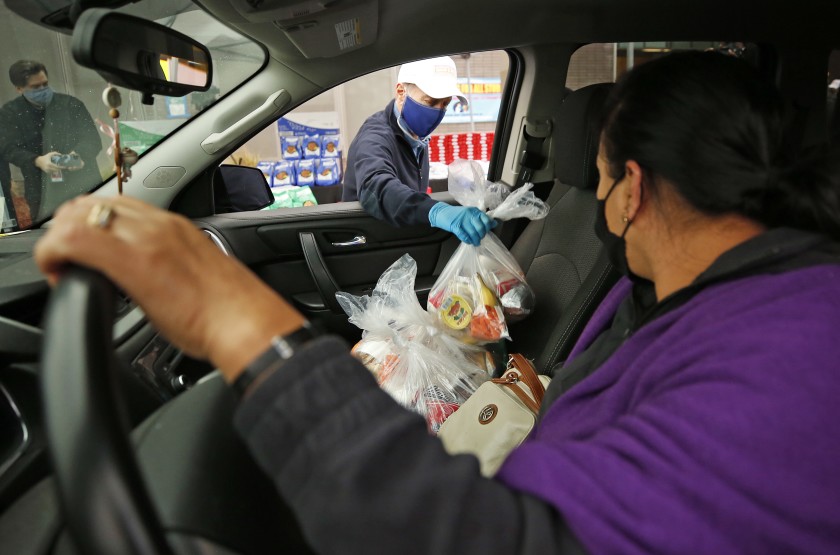 Manuela Antonio thanks LAUSD Supt. Austin Beutner as he helps distribute meals to families at the Grab & Go Food Center at Garfield High School in East Los Angeles.(Al Seib / Los Angeles Times)