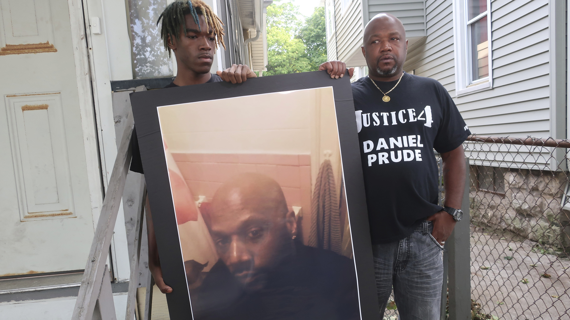 In this Sept. 3, 2020, file photo, Joe Prude, brother of Daniel Prude, right, and his son Armin, stand with a picture of Daniel Prude in Rochester, N.Y. (Ted Shaffre/Associated Press)