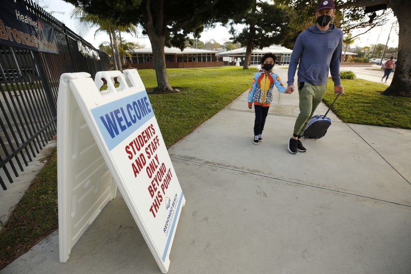 Alik Laddon arrives with his son, first-grader Caden Andino, in 2021 after the reopening of Alta Vista Elementary School in Redondo Beach. (Al Seib / Los Angeles Times)