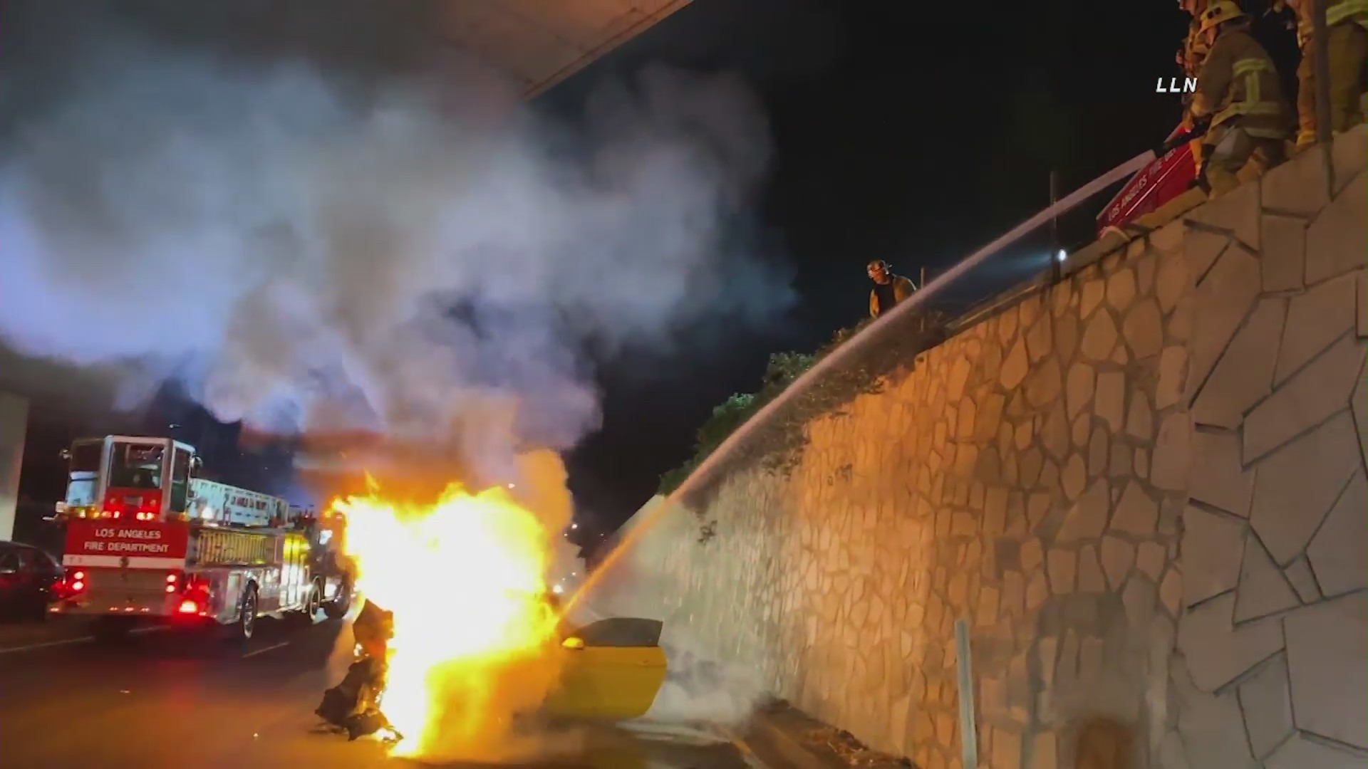 Firefighters work on extinguishing a fire that erupted after a crash on the 110 Freeway near Stadium Way on Feb. 6, 2021. (LLN)