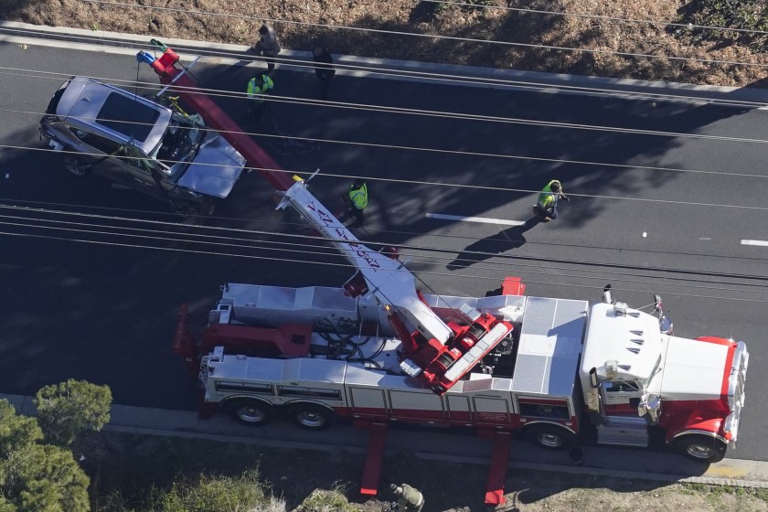 Workers use a crane to move a vehicle after a rollover accident involving golfer Tiger Woods on Tuesday in Rancho Palos Verdes, CA. (Mark J. Terrill / For The Times)