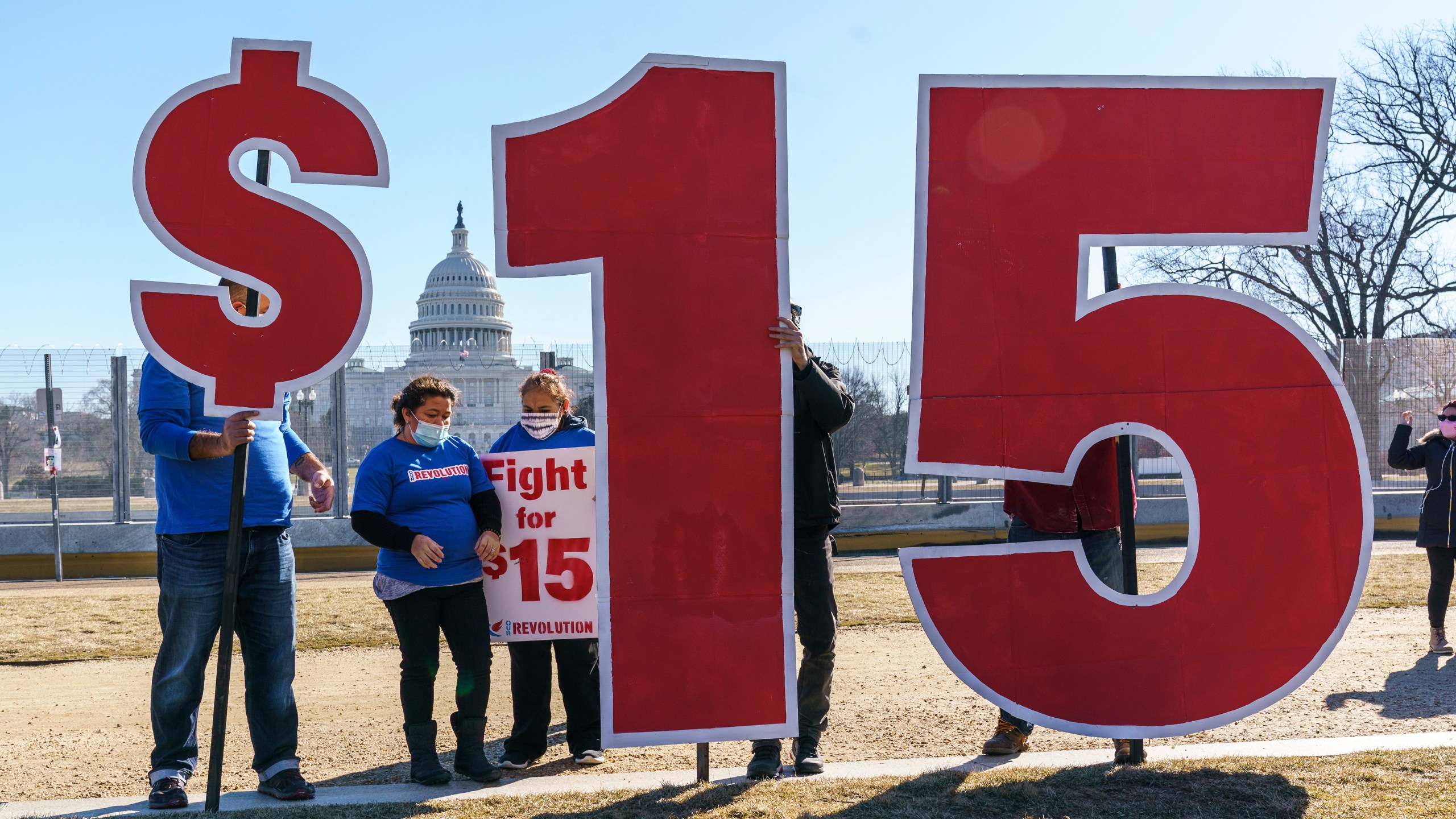 Activists appeal for a $15 minimum wage near the Capitol in Washington, Thursday, Feb. 25, 2021. The $1.9 trillion COVID-19 relief bill being prepped in Congress includes a provision that over five years would hike the federal minimum wage to $15 an hour. (AP Photo/J. Scott Applewhite)