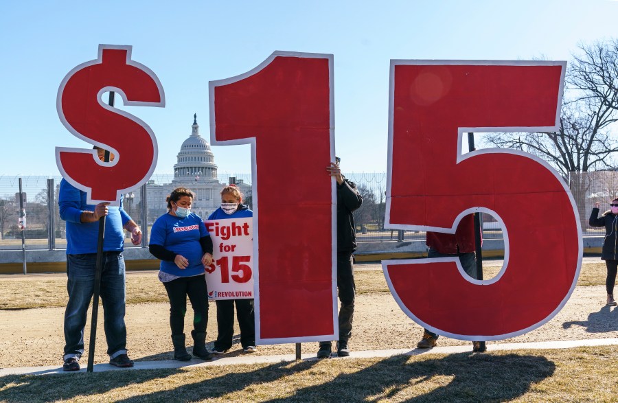 Activists appeal for a $15 minimum wage near the Capitol in Washington, Thursday, Feb. 25, 2021. The $1.9 trillion COVID-19 relief bill being prepped in Congress includes a provision that over five years would hike the federal minimum wage to $15 an hour. (AP Photo/J. Scott Applewhite)