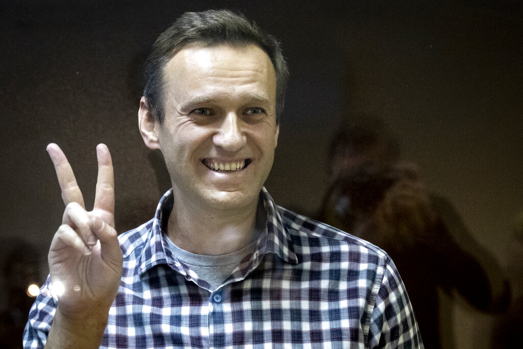 In this Saturday, Feb. 20, 2021 file photo, Russian opposition leader Alexei Navalny gestures as he stands behind a grass of the cage in the Babuskinsky District Court in Moscow, Russia. (AP Photo/Alexander Zemlianichenko, File)