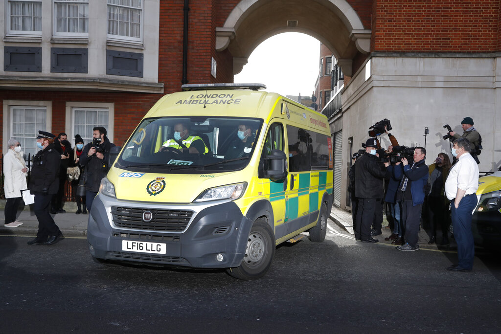 Police officers stand at an entrance to the King Edward VII Hospital where Prince Philip is being treated for an infection, as an ambulance is driven out, in London, Monday, March 1, 2021. (AP Photo/Frank Augstein)