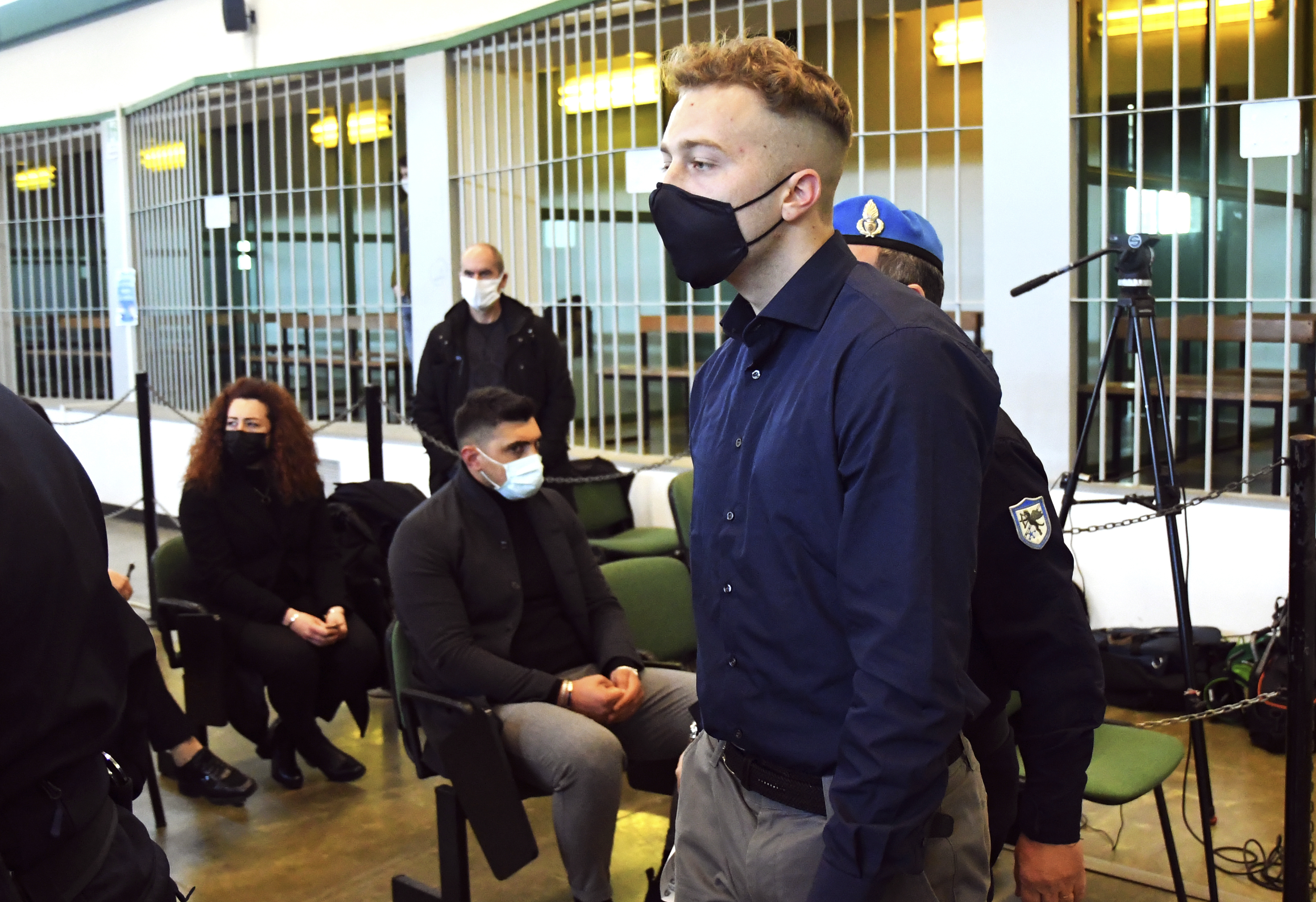 Finnegan Lee Elder, from the United States, walks past to Rosa Maria Esilio, widow of slain Carabinieri military police officer Mario Cerciello Rega, background left, and Paolo Cerciello Rega, brother of Mario, center, on March 1, 2021, prior to a hearing in Rome in the trial where he and Gabriel Natale-Hjorth are accused of slaying a plainclothes Carabinieri officer while on vacation in Italy in July 2019. (Alberto Pizzoli / Associated Press)