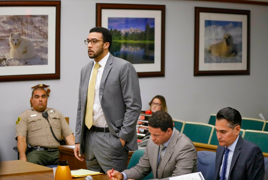 In this June 14, 2019, file photo Ex-NFL player Kellen Winslow II, standing, who was accused of committing several sex crimes against women in North County last year, including rape, answers a question from San Diego County Superior Court Vista Judge Blaine Bowman during a status hearing in Vista, Calif. (Howard Lipin/The San Diego Union-Tribune via AP, Pool,File)