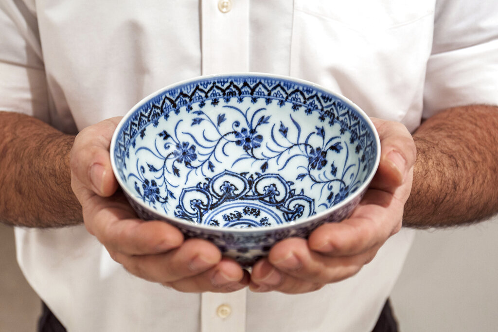 This photo, provided by Sotheby's, in New York, on Tuesday, March 2, 2021, shows a small porcelain bowl bought for $35 at a Connecticut yard sale that turned out to be a rare, 15th century Chinese artifact worth between $300,000 and $500,000. The bowl will be offered in Sotheby's Auction of Important Chinese Art, in New York, on March 17. (Sotheby's via AP)