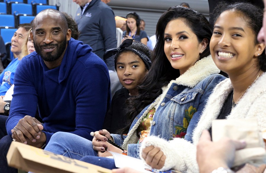 In this Nov. 21, 2017, file photo, from left, Los Angeles Lakers legend Kobe Bryant, his daughter Gianna Maria-Onore Bryant, wife Vanessa and daughter Natalia Diamante Bryant are seen before an NCAA college women's basketball game between Connecticut and UCLA, in Los Angeles. Vanessa Bryant says she is focused on “finding the light in darkness” in an emotional story in People magazine. She details how she attempts to push forward after her husband, Kobe Bryant, and daughter Gigi died in a helicopter crash in early 2020. (AP Photo/Reed Saxon, File)