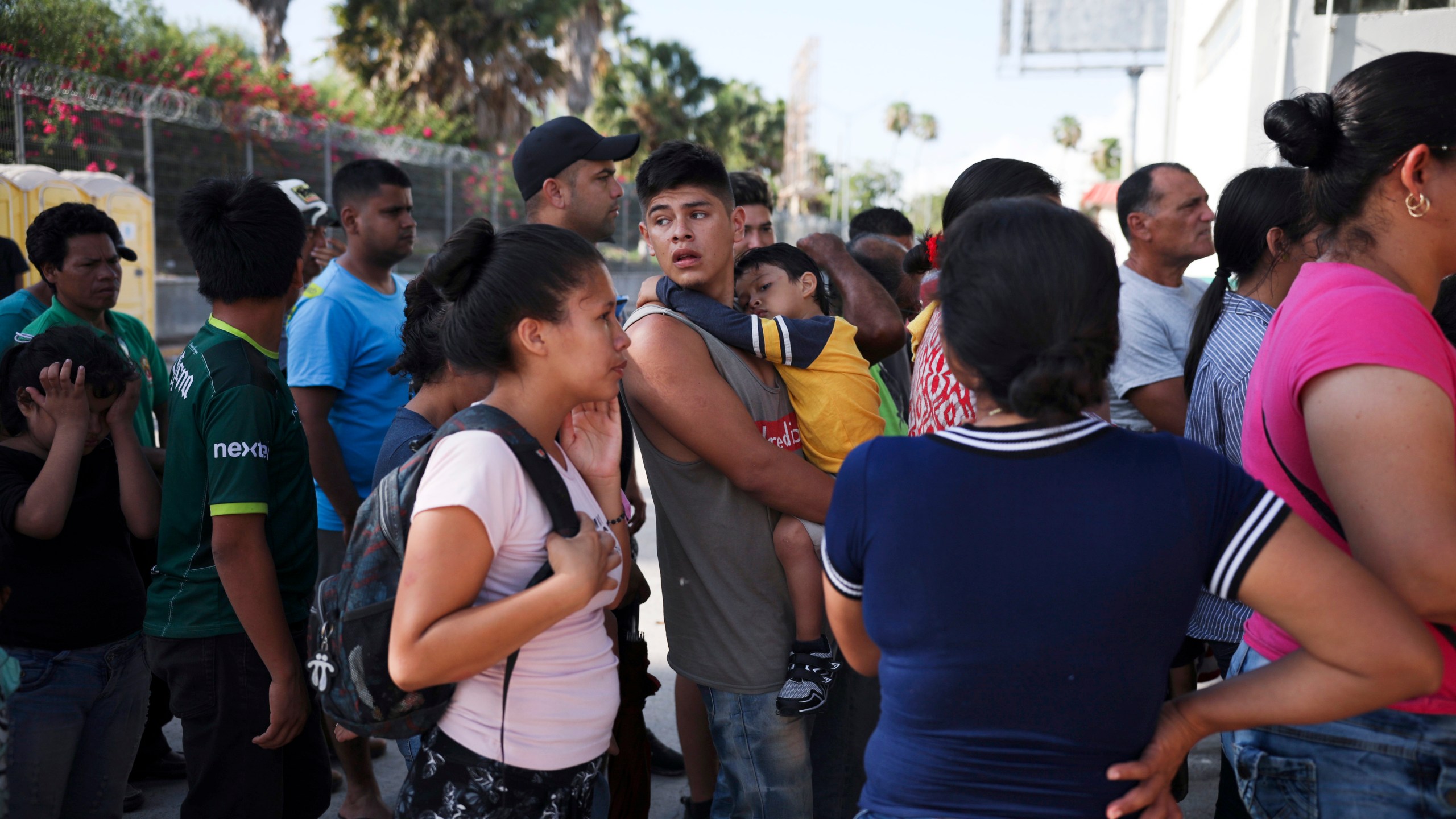 In this July 31, 2019 file photo, migrants line up in Matamoros, Mexico, for a meal donated by volunteers from the U.S., at the foot of the Puerta Mexico bridge that crosses to Brownsville, Texas. (AP Photo/Emilio Espejel, File)