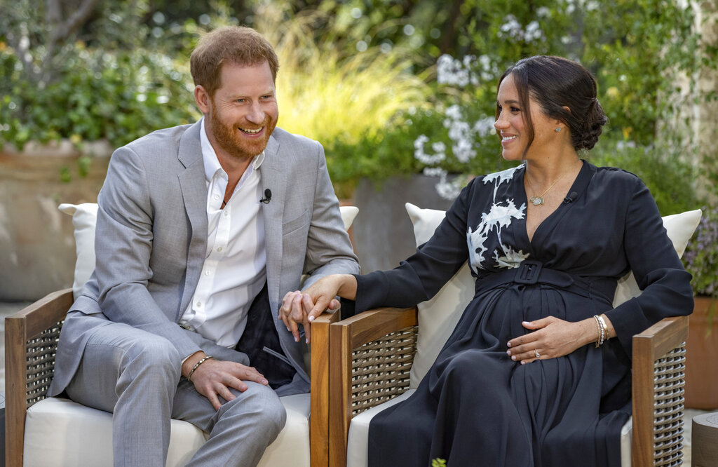 This image provided by Harpo Productions shows Prince Harry, left, and Meghan, Duchess of Sussex, speaking about expecting their second child during an interview with Oprah Winfrey. (Joe Pugliese/Harpo Productions via AP)