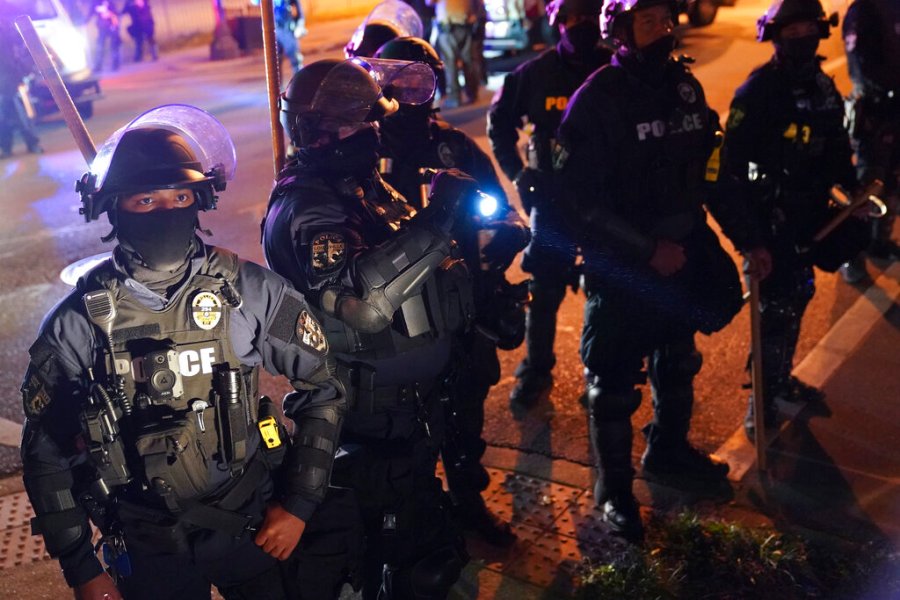 In this Thursday, Sept. 24, 2020, file photo, police speak with protesters at the First Unitarian church, in Louisville, Ky. (AP Photo/John Minchillo, File)