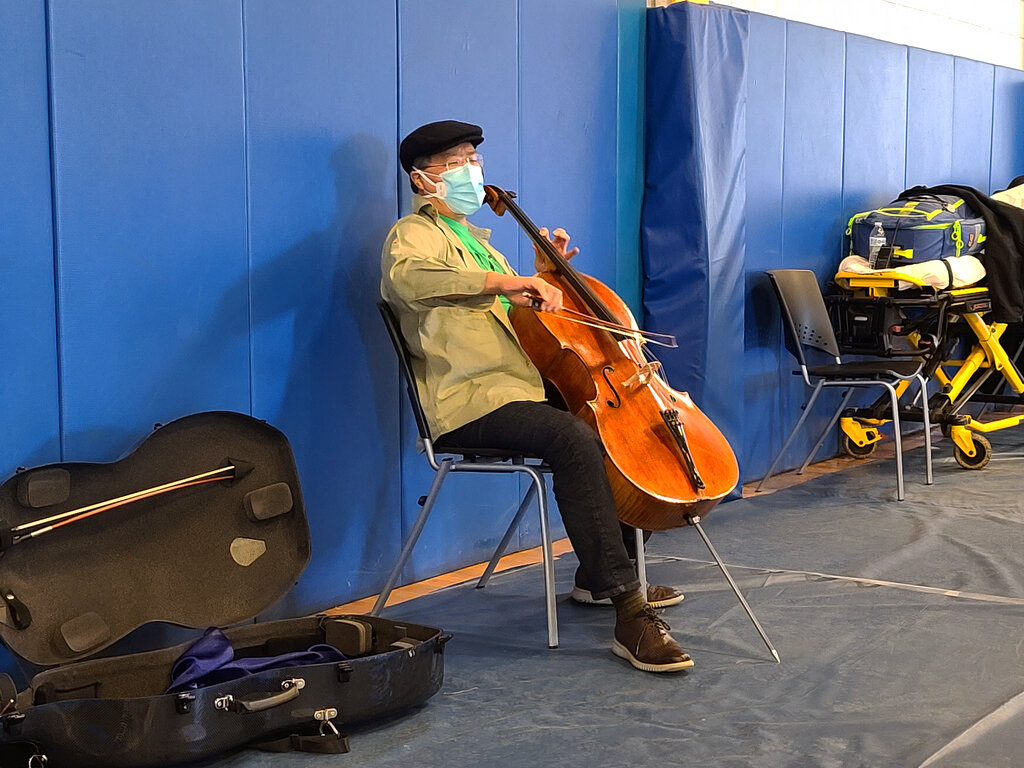 This photo provided by Berkshire Community College shows cellist Yo-Yo Ma performing at Berkshire Community College’s second dose Pfizer vaccination clinic in the Paterson Field House on Saturday, March 13, 2021 in Pittsfield, Mass. (Jonah Sykes/Berkshire Community College via AP)