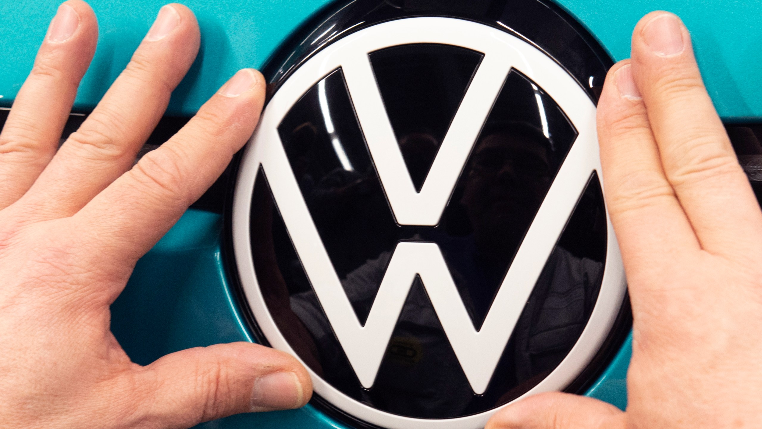 In this Feb. 25, 2020, file photo, a worker completes an electric car ID.3 body at the assembly line during a press tour at the plant of the German manufacturer Volkswagen AG (VW) in Zwickau, eastern Germany. (AP Photo/Jens Meyer, file)