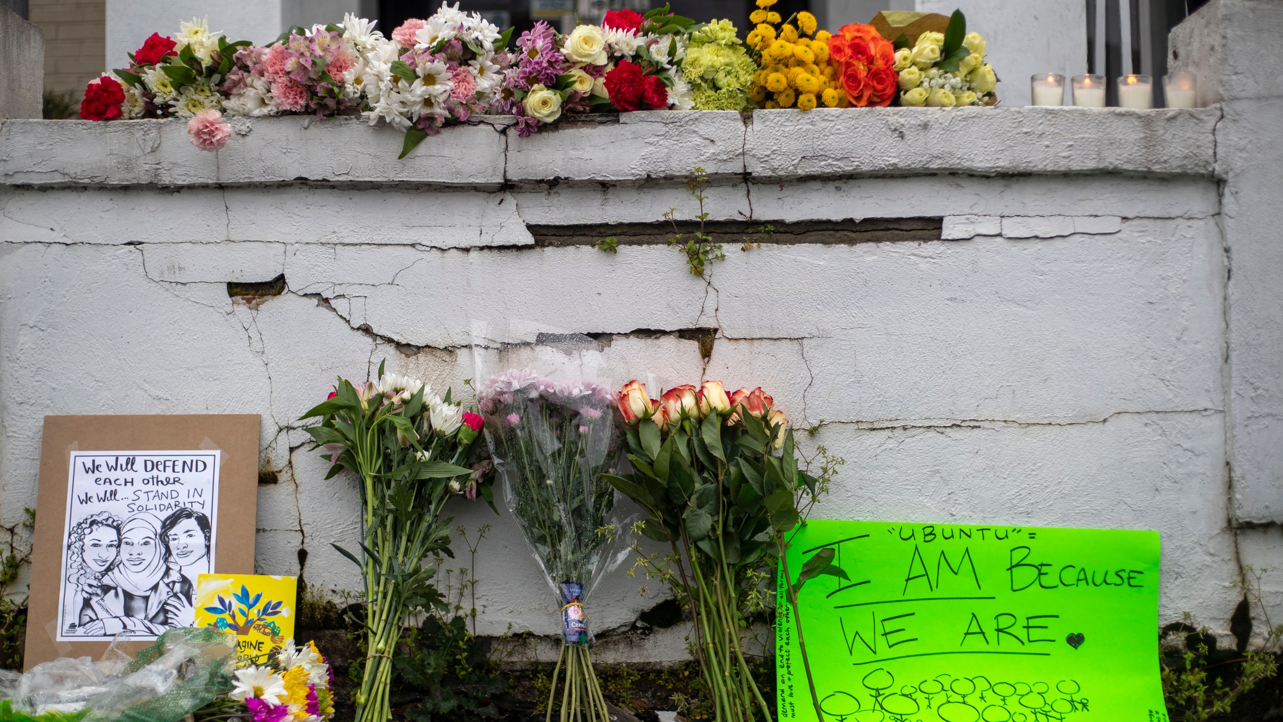 Flowers and signs are displayed at a makeshift memorial outside of the Gold Spa in Atlanta, Wednesday, March 17, 2021. (Alyssa Pointer/Atlanta Journal-Constitution via AP)