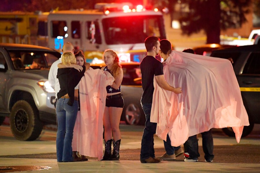 In this Thursday, Nov. 8, 2018, file photo, people comfort each other as they stand near the scene in Thousand Oaks, Calif. (AP Photo/Mark J. Terrill)