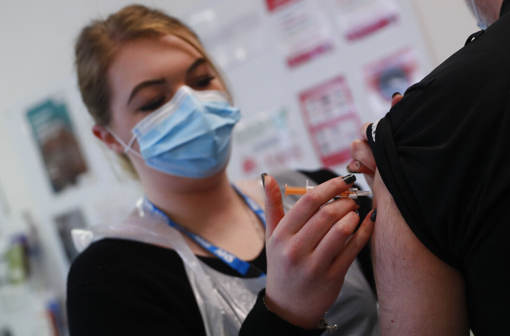 Pharmacy Technician Katrina Bonwick administers a dose of the AstraZeneca COVID-19 vaccine at the Wheatfield surgery in Luton, England, Thursday, March 18, 2021. (AP Photo/Alastair Grant)