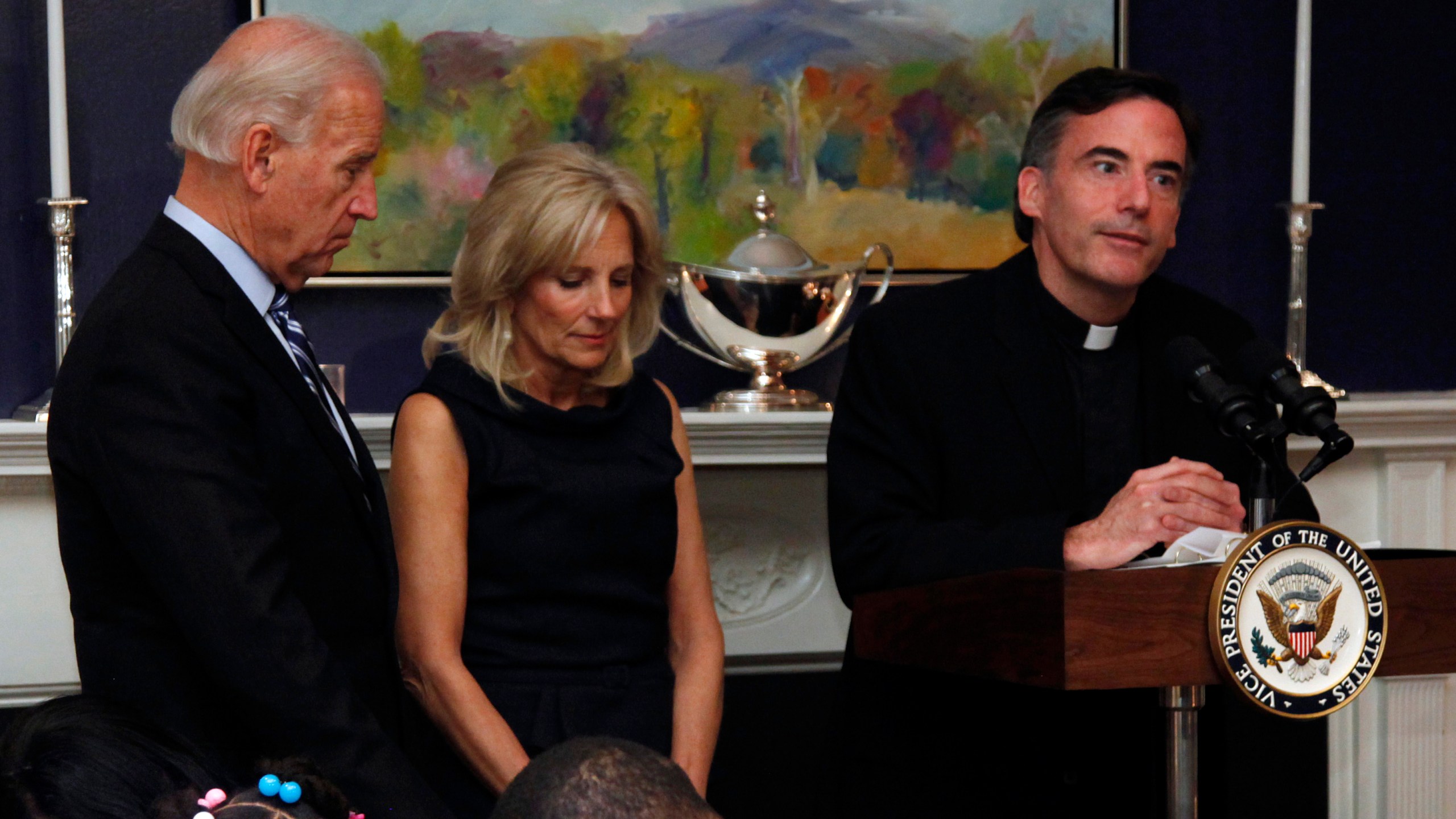 In this Nov. 22, 2010 file photo, then Vice President Joe Biden and his wife, Jill Biden stand with heads bowed as the Rev. Kevin O'Brien says the blessing during a Thanksgiving meal for Wounded Warriors in Washington. (Carolyn Kaster/Associated Press)