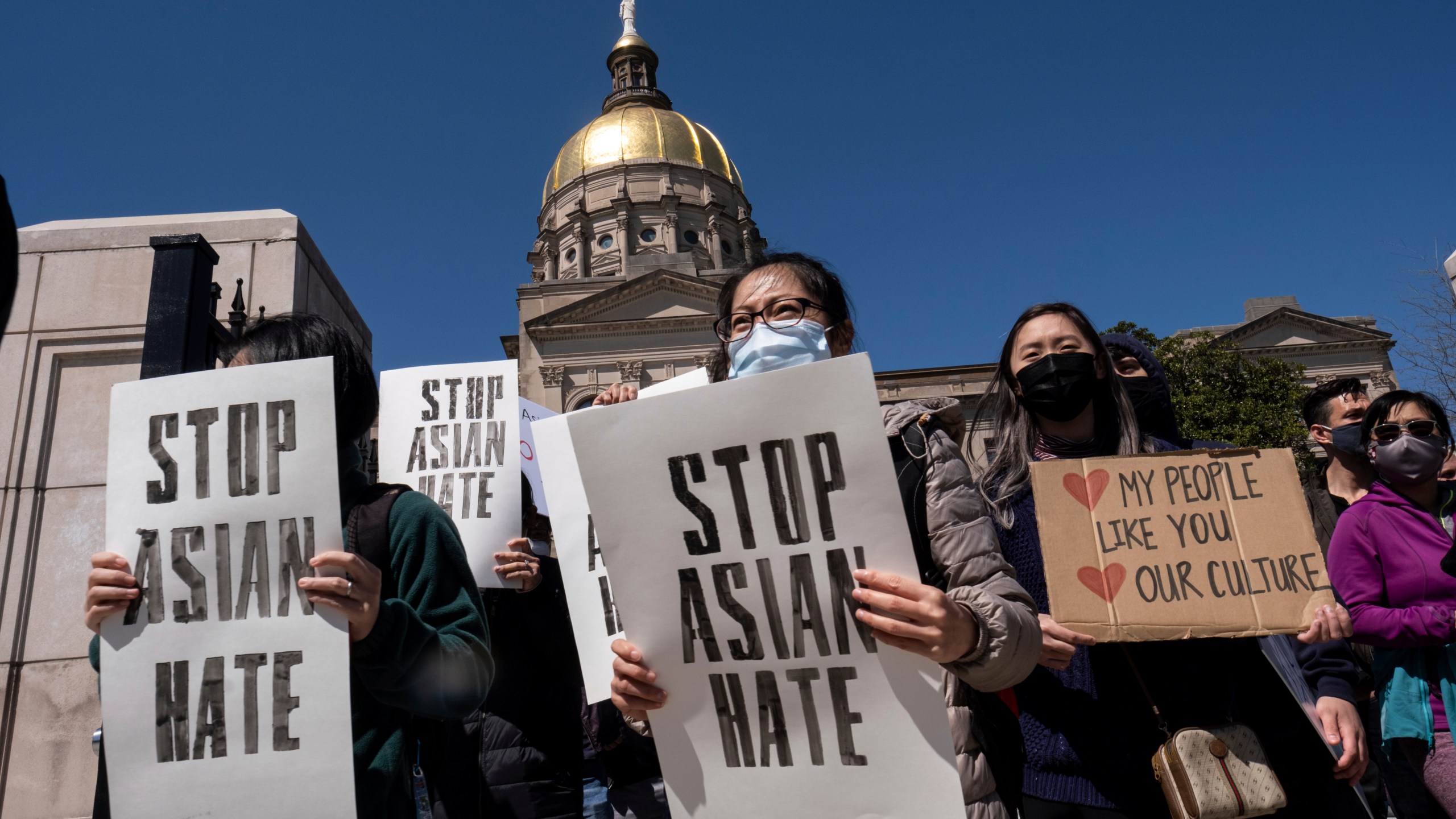 People hold signs while participating in a "stop Asian hate" rally outside the Georgia State Capitol in Atlanta on Saturday afternoon, March 20, 2021. (AP Photo/Ben Gray)