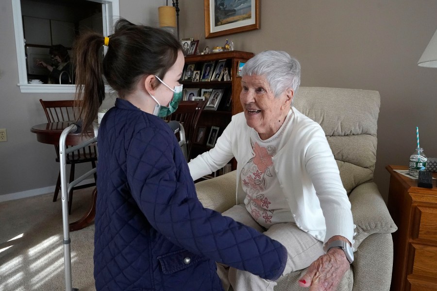 Eileen Quinn, 98, right, a resident at New Pond Village retirement community in Walpole, Mass., greets her great-granddaughter Maeve Whitcomb, 6, at the retirement community in Walpole on March 21, 2021. (Steven Senne/Associated Press)