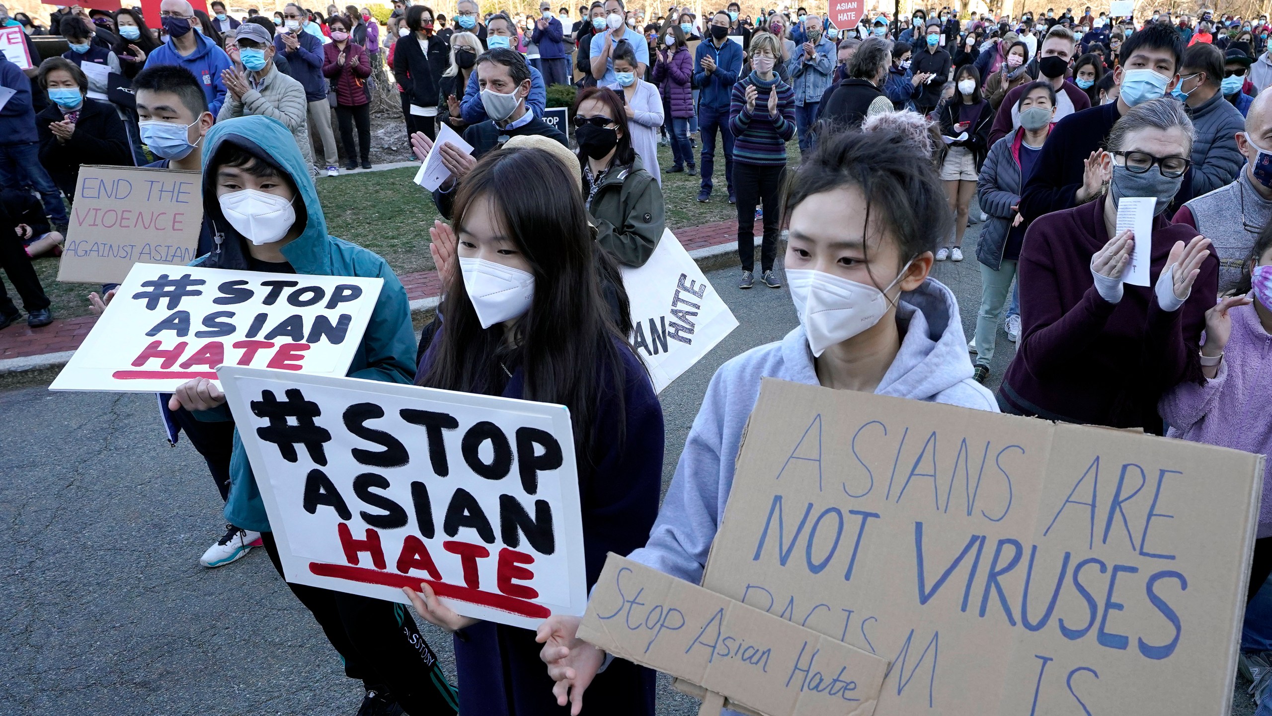 Protesters display placards during a rally held to support Stop Asian Hate, Sunday, March 21, 2021, in Newton, Massachusetts. (AP Photo/Steven Senne)