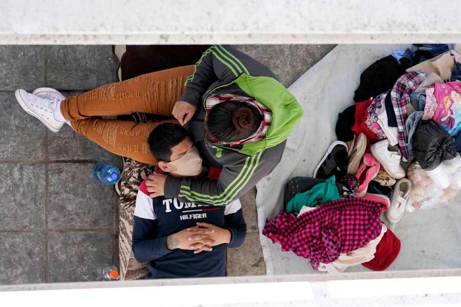 Migrants who were caught trying to cross into the U.S. and were deported rest under a ramp that leads to the McAllen-Hidalgo International Bridge in Reynosa, Mexico, on March 18, 2021. (Julio Cortez / Associated Press)