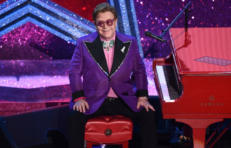 In this Sunday, Feb. 9, 2020, file photo, Elton John appears after performing his nominated song, "(I'm Gonna) Love Me Again," at the Oscars in Los Angeles. Attending Elton John’s long-running Oscar-night party has always been one of the hardest tickets to get. Now you can go — if you have $20. The Elton John AIDS Foundation is inviting everyone to a hour-long, virtual pre-show Oscar party special hosted by Neil Patrick Harris and with a performance by Dua Lipa. Tickets for the April 25 event are $19.99 and are available via Ticketmaster. Proceeds will go to young people at risk and living with HIV all over the world. (AP Photo/Chris Pizzello, File)