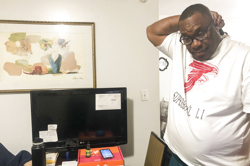 Armetrius Neason poses for a photo inside his room at the Efficiency Lodge hotel outside Atlanta on March 16, 2021. (AP Photo/Sudhin S. Thanawala)