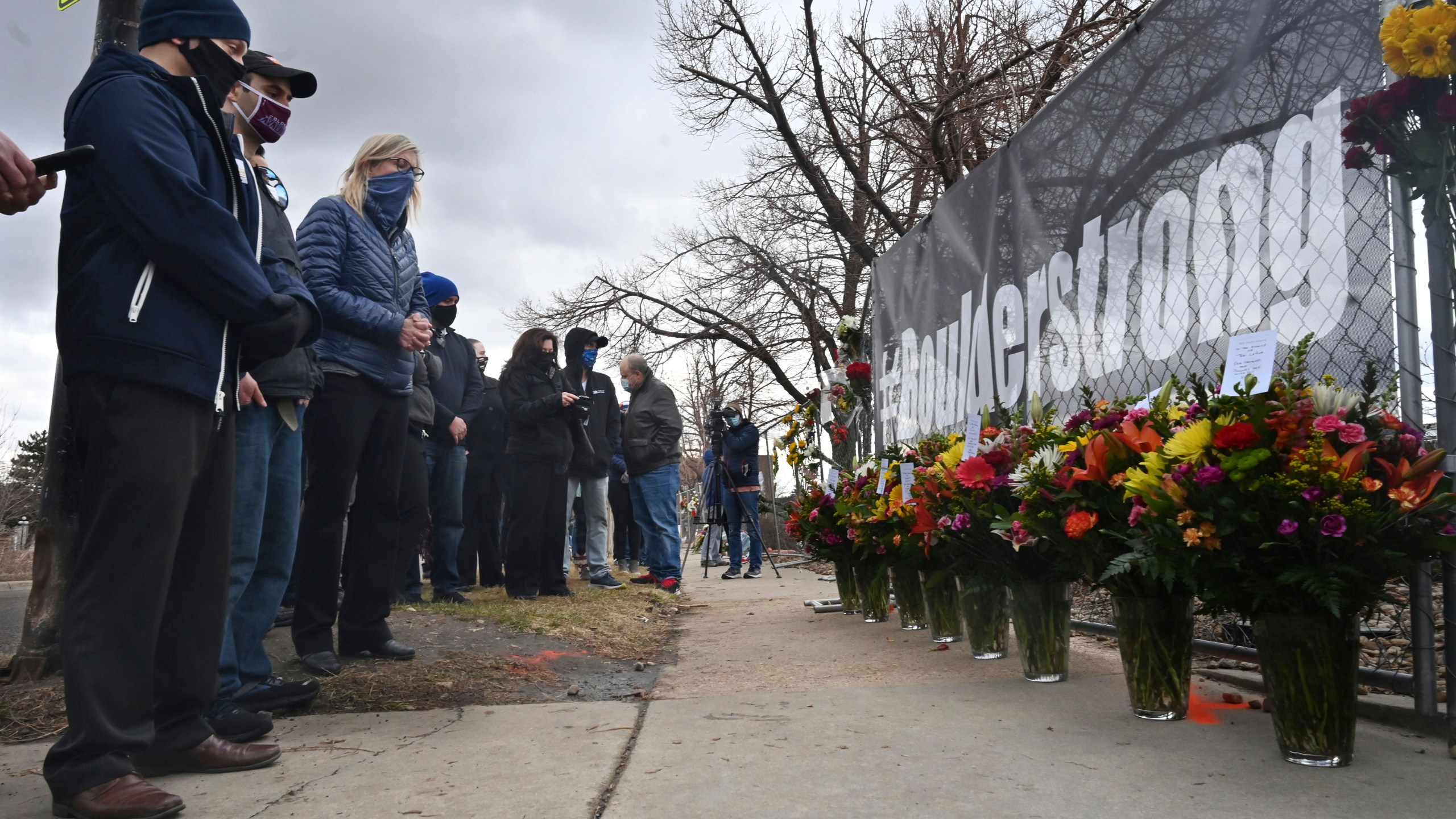 A solemn group of King Soopers employees, left, some from the Boulder store and some from the same district, brought large displays of flowers for each of the victims of a mass shooting at a Boulder Kings Soopers store. (Jerilee Bennett/The Gazette via Associated Press)