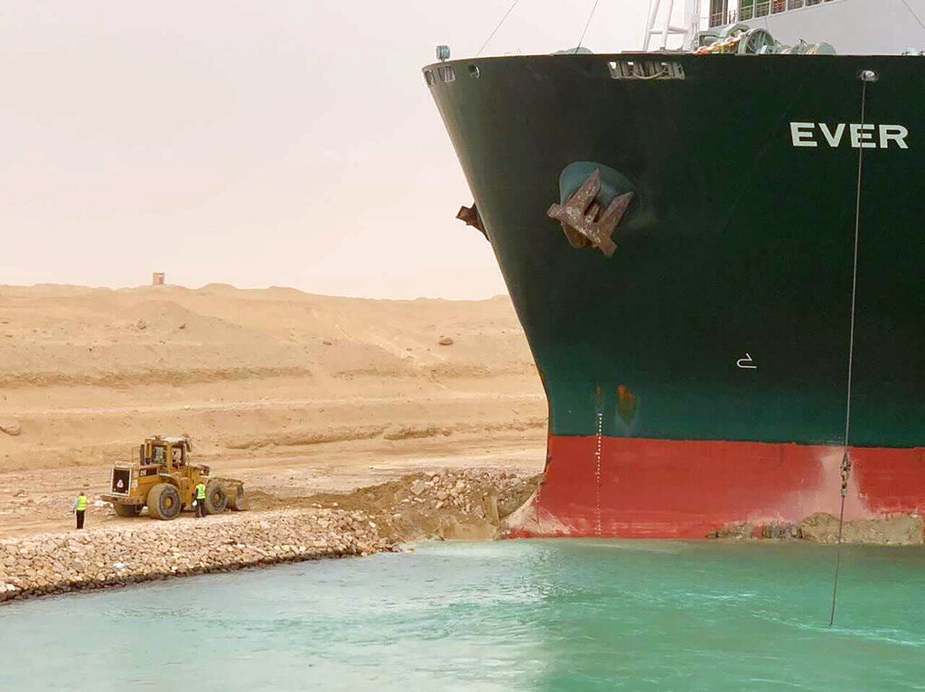 In this photo released by the Suez Canal Authority, a cargo ship, named the Ever Green, sits with its bow stuck into the wall Wednesday, March 24, 2021, after it turned sideways in Egypt’s Suez Canal, blocking traffic in a crucial East-West waterway for global shipping. (Suez Canal Authority via AP)