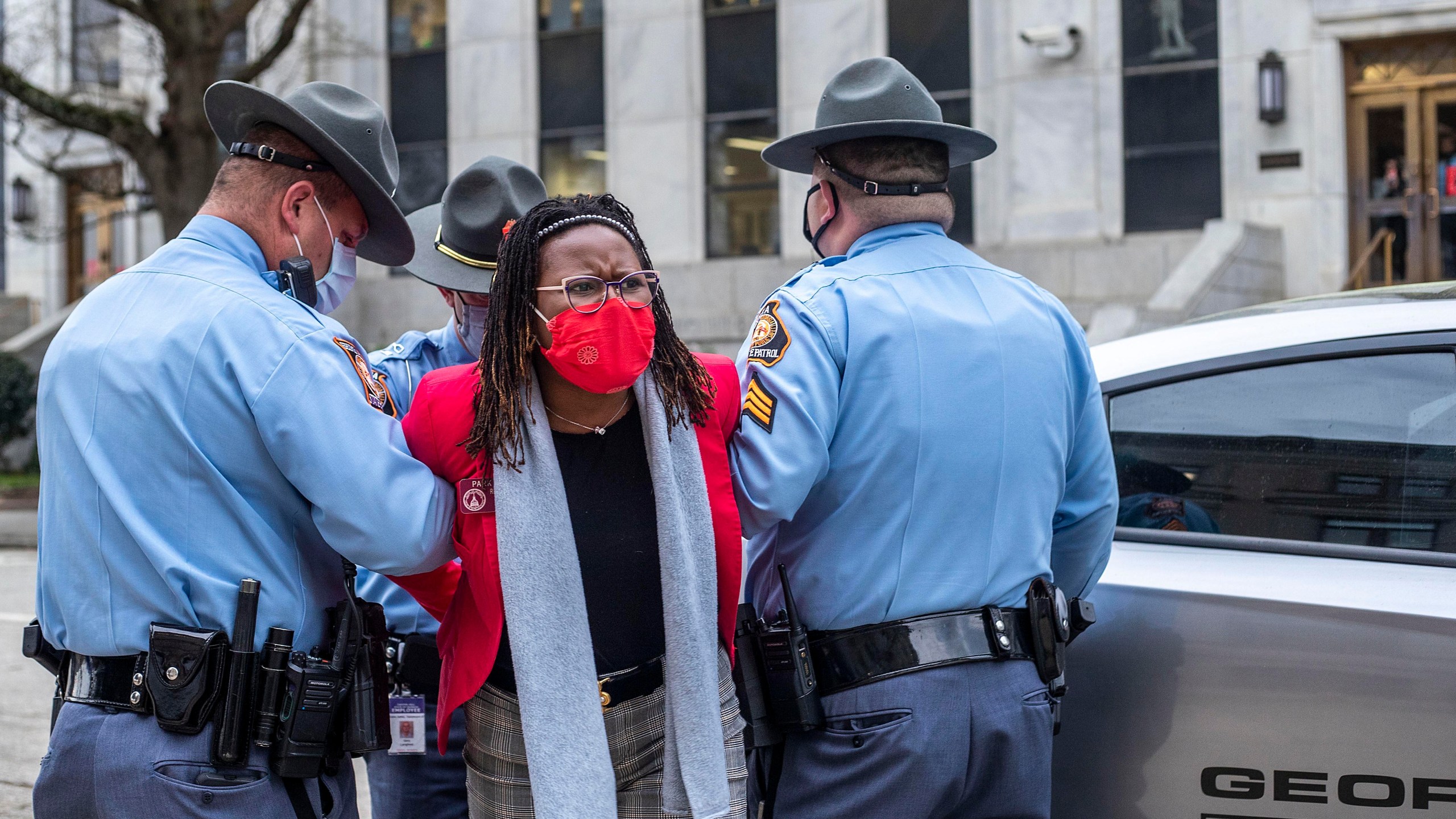 State Rep. Park Cannon, D-Atlanta, is placed into the back of a Georgia State Capitol patrol car after being arrested by Georgia State Troopers at the Georgia State Capitol Building in Atlanta, Thursday, March 25, 2021. Cannon was arrested by Capitol police after she attempted to knock on the door of the Gov. Brian Kemp office during his remarks after he signed into law a sweeping Republican-sponsored overhaul of state elections that includes new restrictions on voting by mail and greater legislative control over how elections are run. (Alyssa Pointer/Atlanta Journal-Constitution via AP)