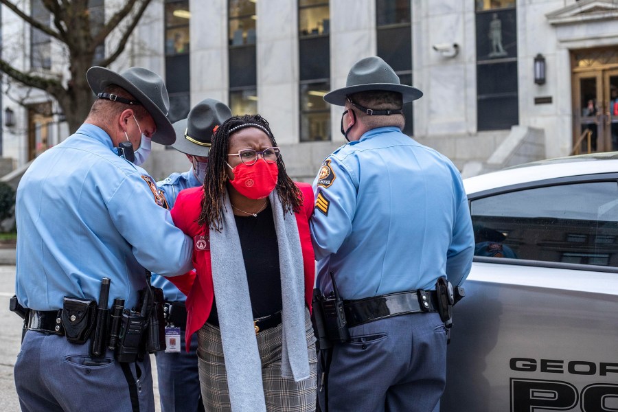 State Rep. Park Cannon, D-Atlanta, is placed into the back of a Georgia State Capitol patrol car after being arrested by Georgia State Troopers at the Georgia State Capitol Building in Atlanta, Thursday, March 25, 2021. Cannon was arrested by Capitol police after she attempted to knock on the door of the Gov. Brian Kemp office during his remarks after he signed into law a sweeping Republican-sponsored overhaul of state elections that includes new restrictions on voting by mail and greater legislative control over how elections are run. (Alyssa Pointer/Atlanta Journal-Constitution via AP)