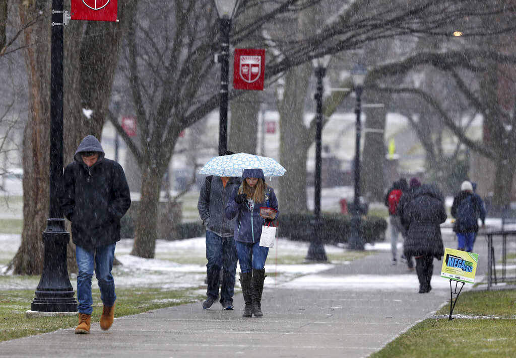 In this Tuesday, Jan. 31, 2017, file photo, people walk in a snowfall at Rutgers University in New Brunswick, N.J. (AP Photo/Mel Evans, File)