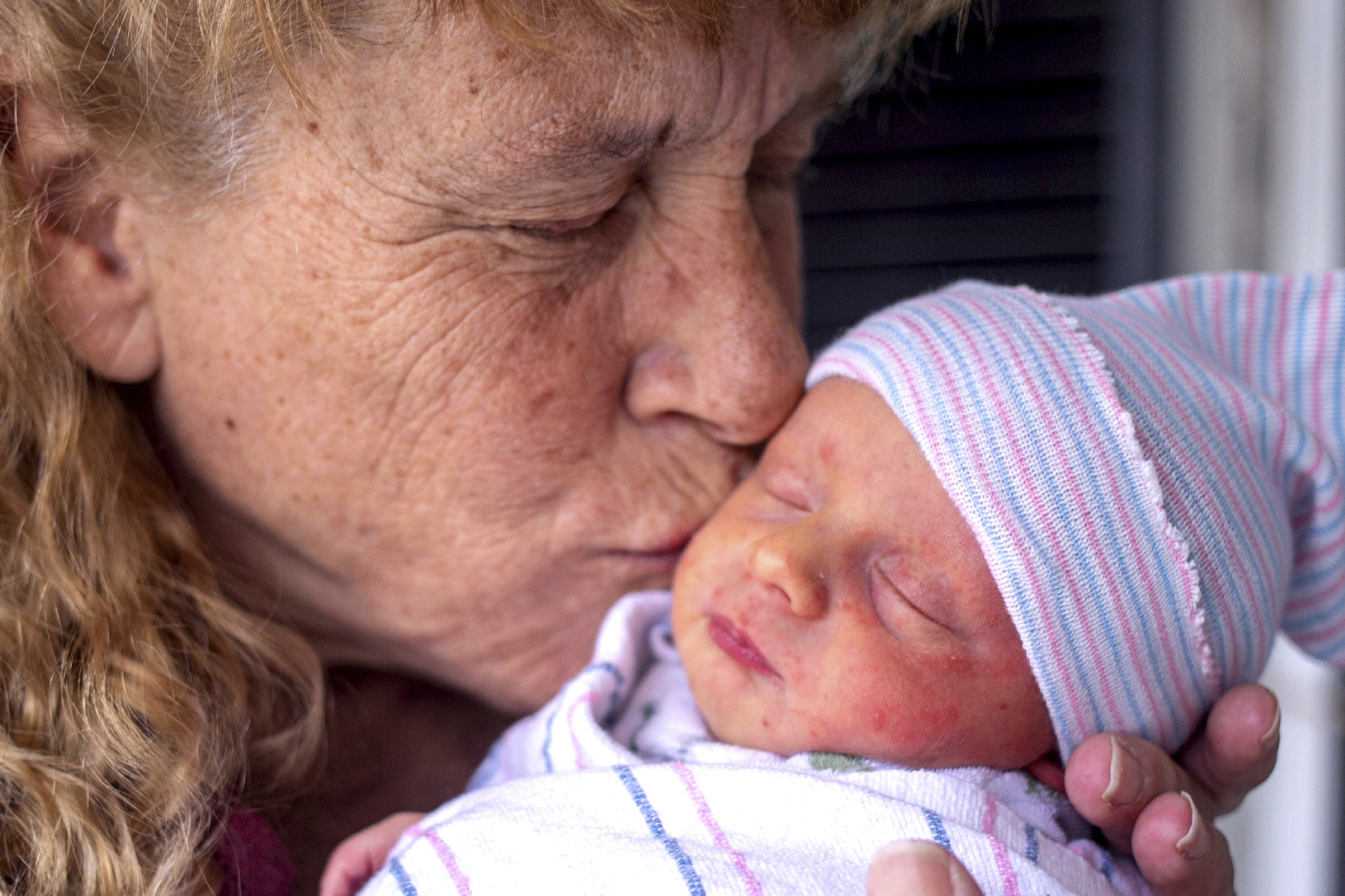 Barbara Higgins cradles her newborn's head in her the family home on Wednesday, March 24, 2021 in Concord, N.H. Higgins who lost her 13-year-old daughter to a brain tumor in 2016 has given birth to a son at age 57. Barbara Higgins, and her husband, Kenny Banzhoff, of Concord, have been dealing with grief over the death of their daughter, Molly. (Geoff Forester/The Concord Monitor via AP)