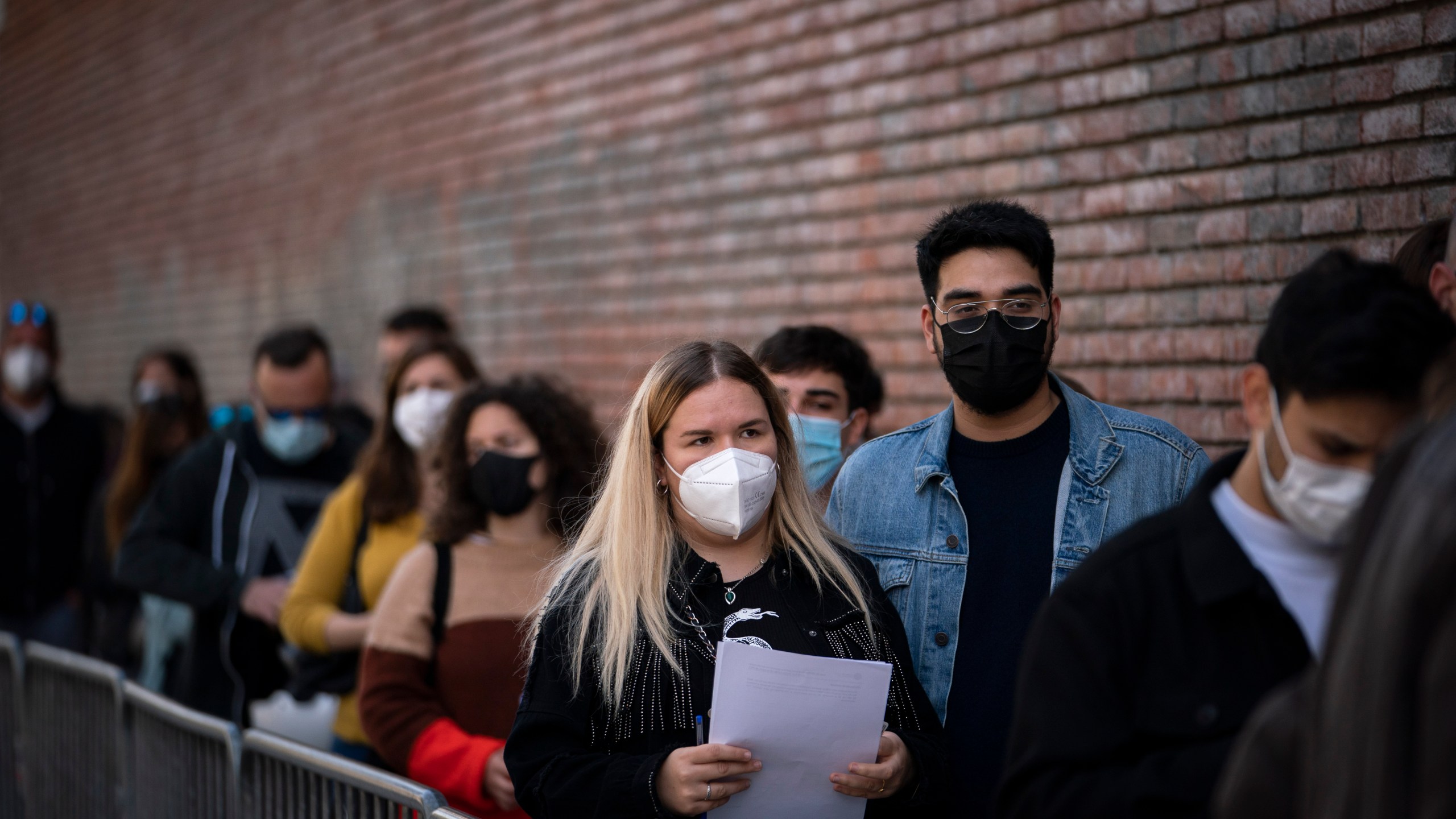 People line up outside a club to be screened for the coronavirus ahead of a music concert in Barcelona, Spain, Saturday, March 27, 2021. Five thousand music lovers are set to attend a rock concert in Barcelona on Saturday after passing a same-day COVID-19 screening to test its effectiveness in preventing outbreaks of the virus at large cultural events. The show by Spanish rock group Love of Lesbian has the special permission of Spanish health authorities. While the rest of the country is limited to gatherings of no more than four people in closed spaces, the concertgoers will be able to mix freely while wearing face masks. (AP Photo/Emilio Morenatti)