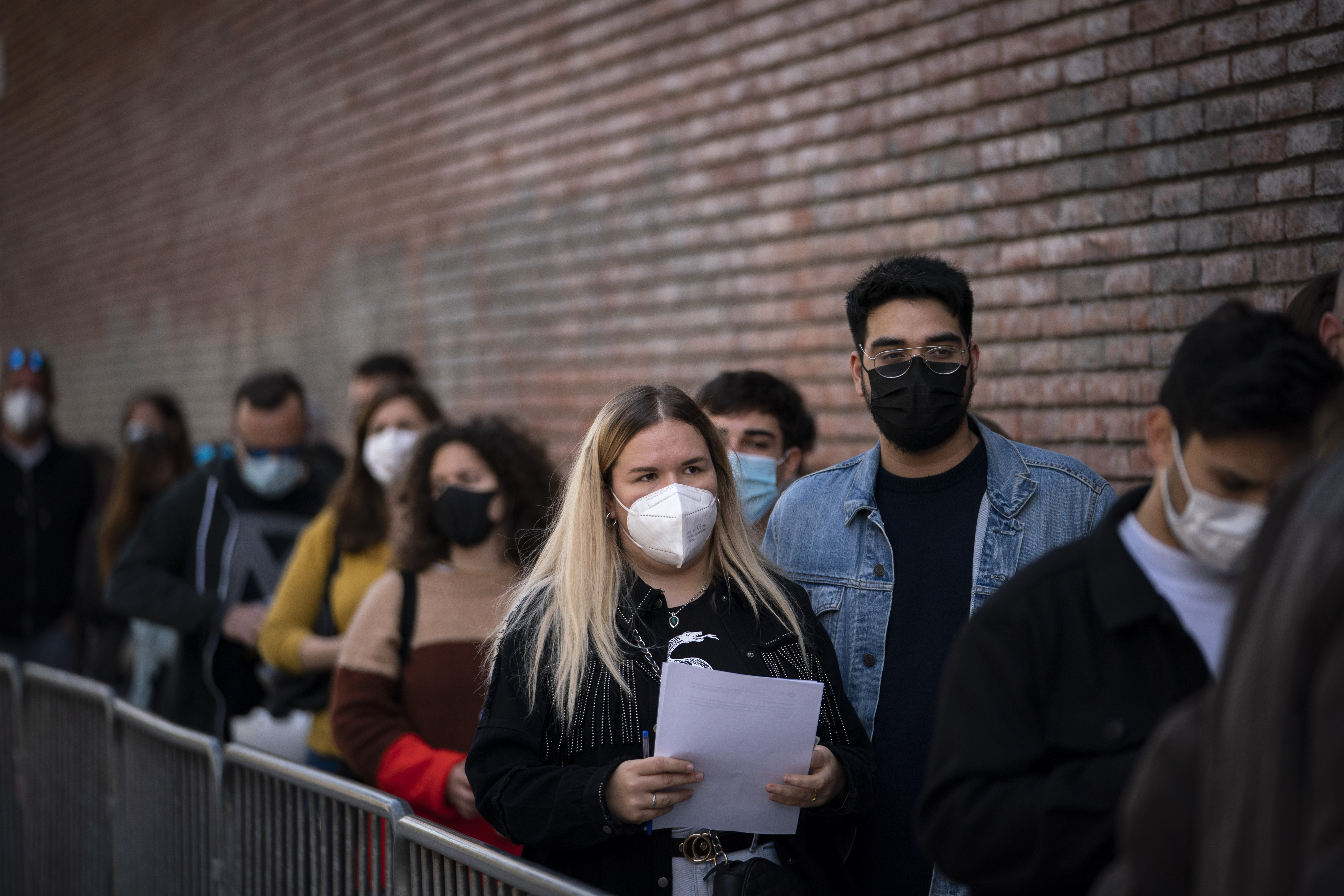 People line up outside a club to be screened for the coronavirus ahead of a music concert in Barcelona, Spain, Saturday, March 27, 2021. Five thousand music lovers are set to attend a rock concert in Barcelona on Saturday after passing a same-day COVID-19 screening to test its effectiveness in preventing outbreaks of the virus at large cultural events. The show by Spanish rock group Love of Lesbian has the special permission of Spanish health authorities. While the rest of the country is limited to gatherings of no more than four people in closed spaces, the concertgoers will be able to mix freely while wearing face masks. (AP Photo/Emilio Morenatti)