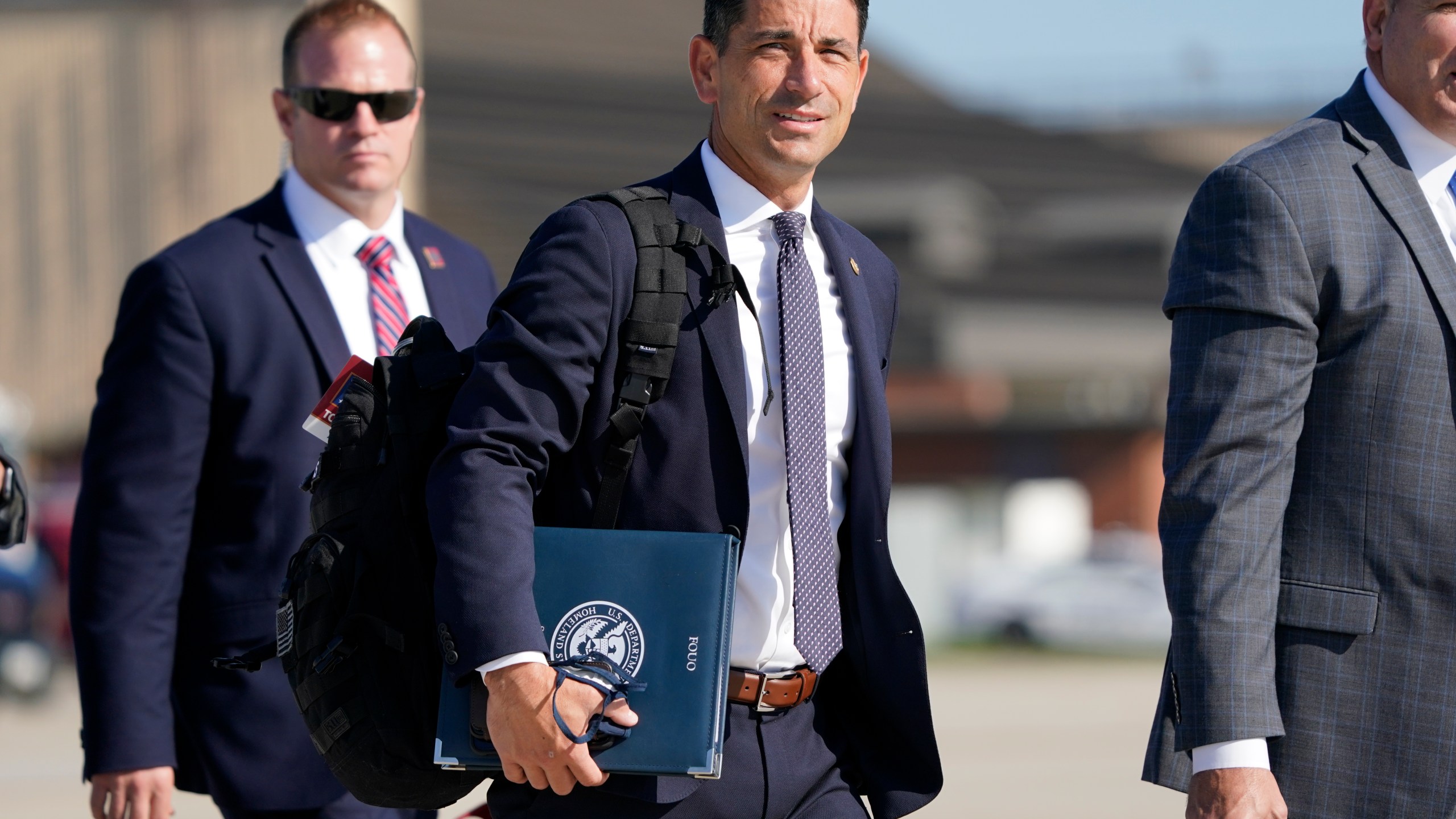 In this Aug. 18, 2020, file photo acting-Secretary of Homeland Security Chad Wolf, center, arrives to join President Donald Trump at Andrews Air Force Base in Md. (AP Photo/J. Scott Applewhite, File)