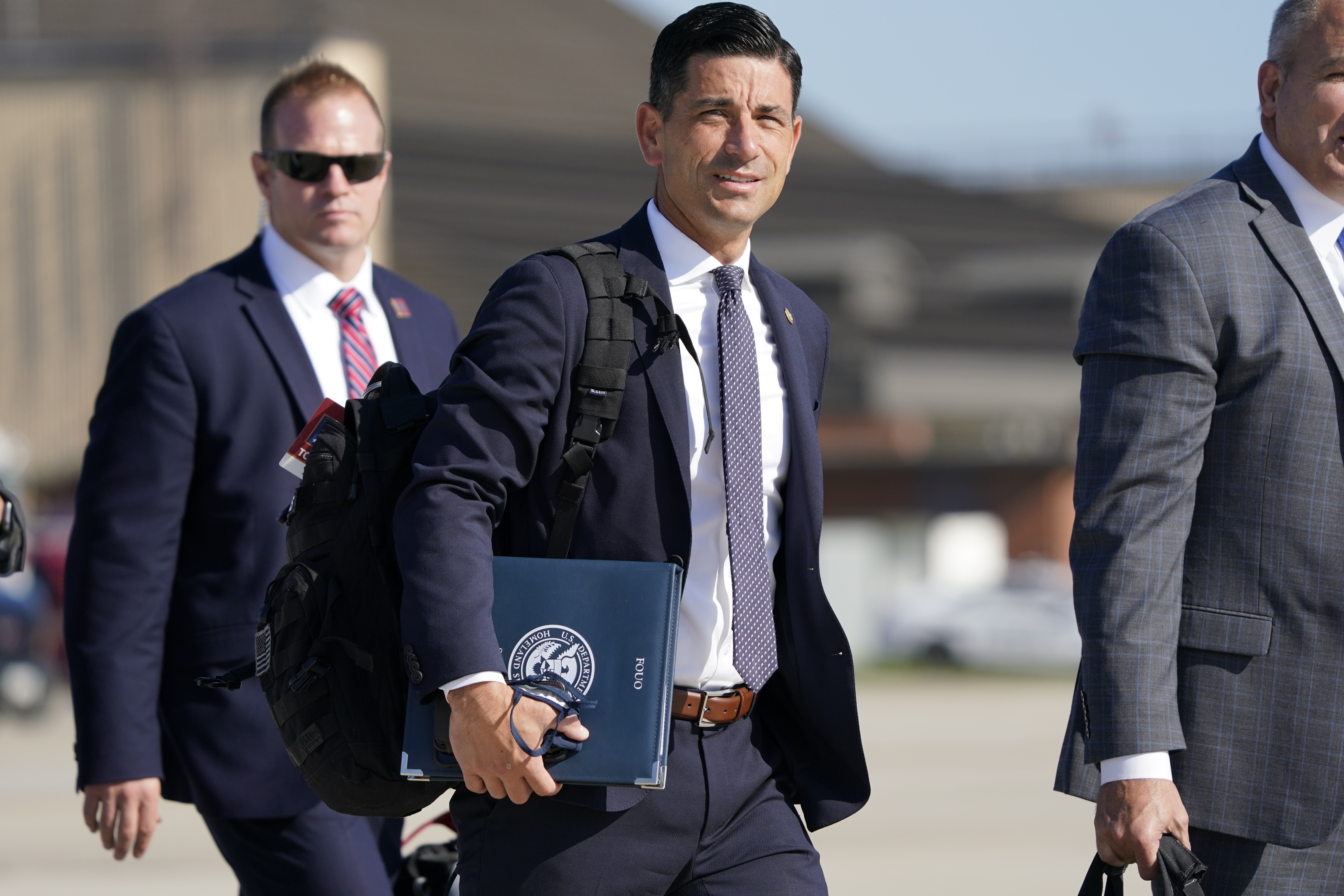 In this Aug. 18, 2020, file photo acting-Secretary of Homeland Security Chad Wolf, center, arrives to join President Donald Trump at Andrews Air Force Base in Md. (AP Photo/J. Scott Applewhite, File)