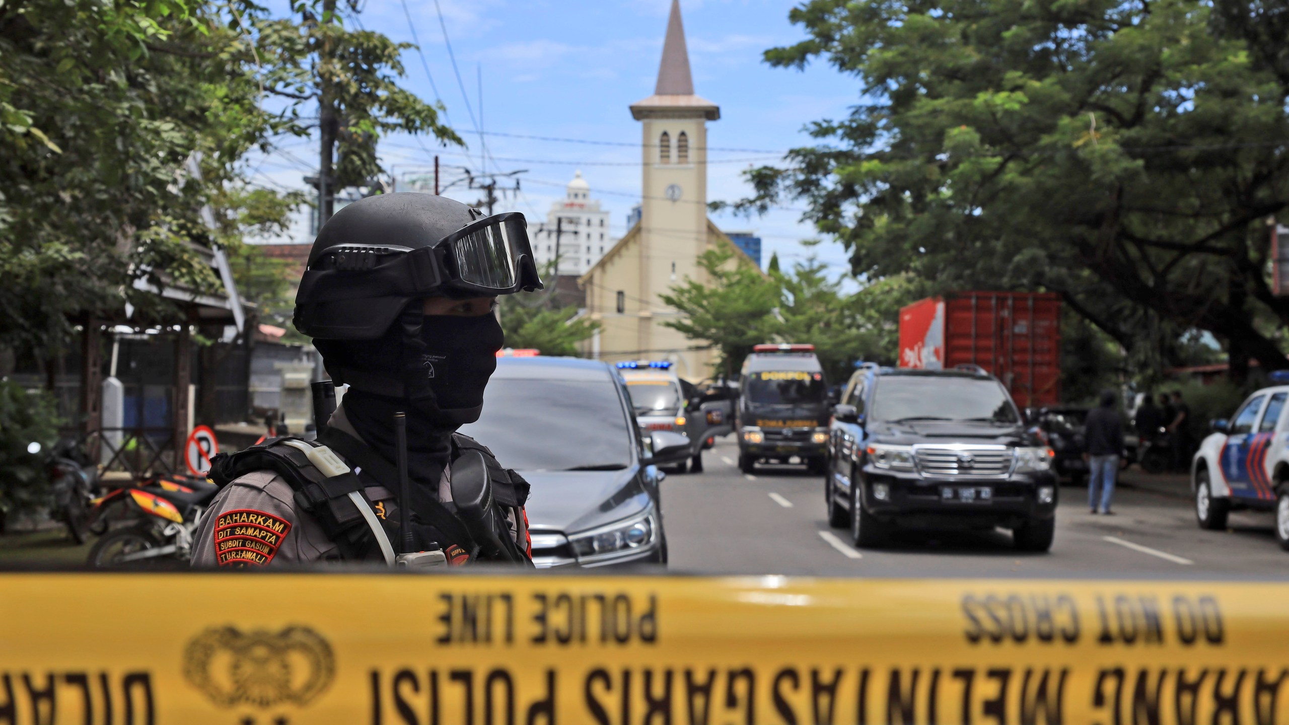 A police officer stands guard near a church where an explosion went off in Makassar, South Sulawesi, Indonesia, Sunday, March 28, 2021. (AP Photo/Yusuf Wahil)