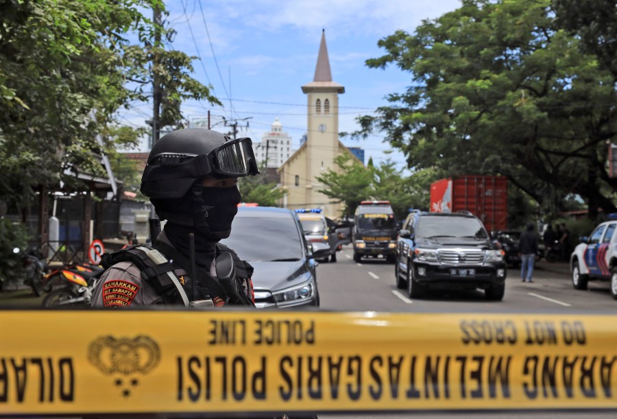 A police officer stands guard near a church where an explosion went off in Makassar, South Sulawesi, Indonesia, Sunday, March 28, 2021. (AP Photo/Yusuf Wahil)