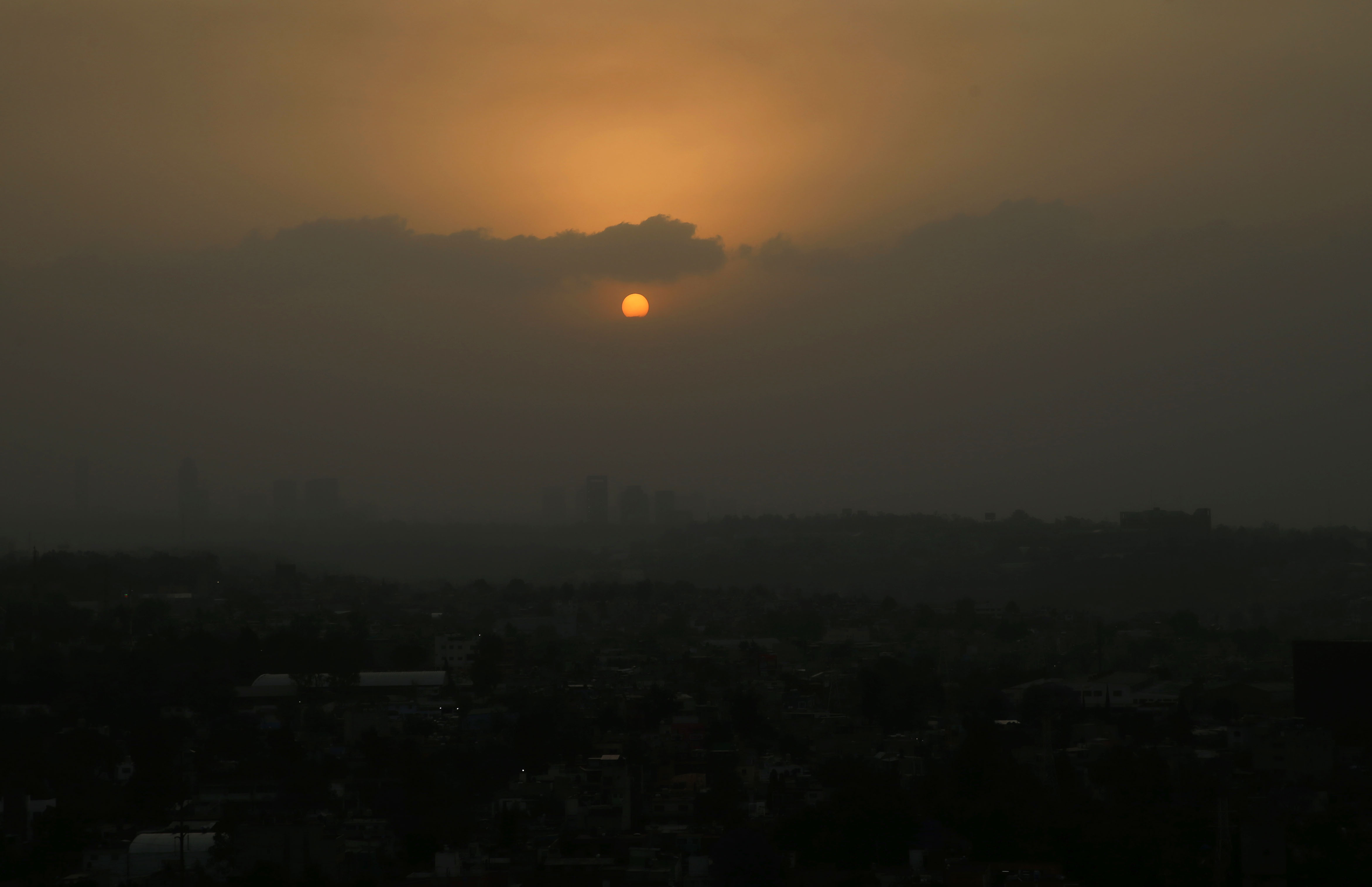 The sun sets amid a dust storm in Mexico City, Sunday, March. 28, 2021. (AP Photo/Marco Ugarte)