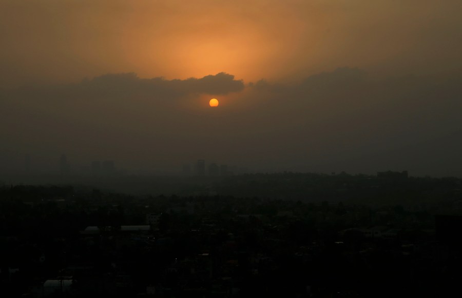 The sun sets amid a dust storm in Mexico City, Sunday, March. 28, 2021. (AP Photo/Marco Ugarte)