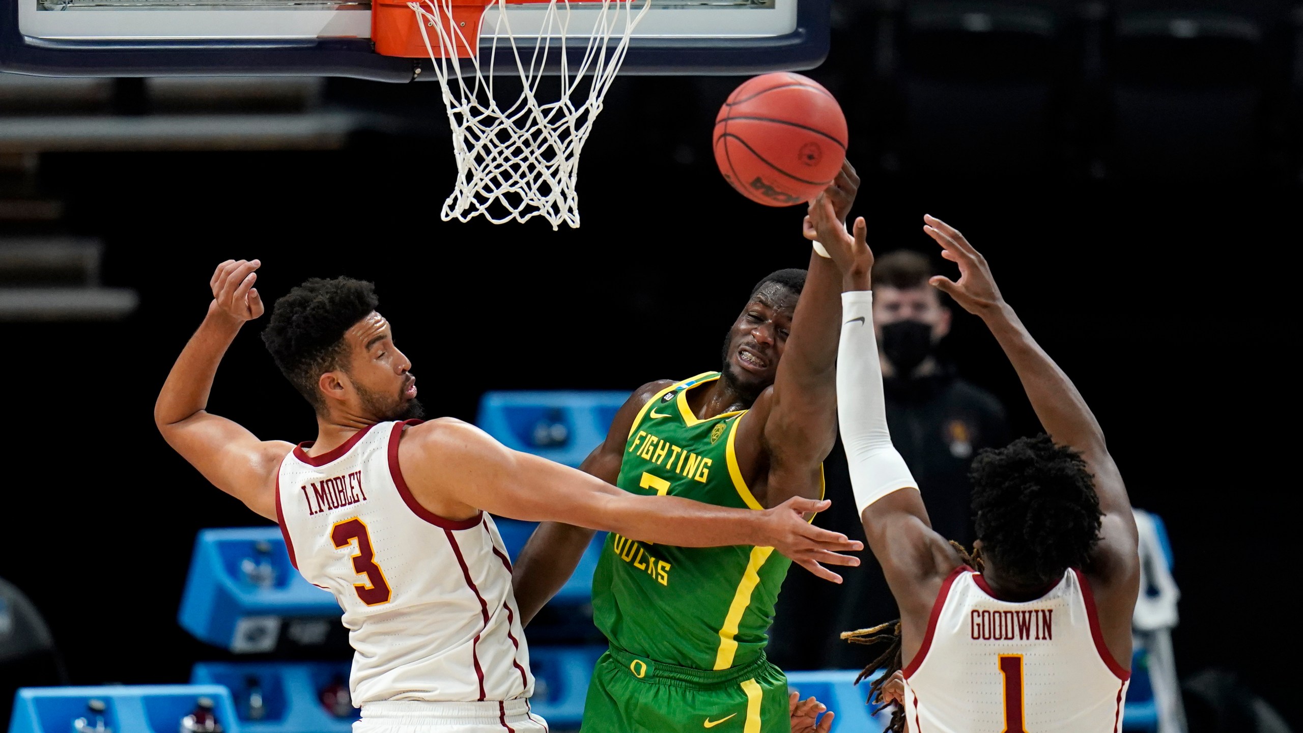 Oregon forward Eugene Omoruyi, center, fights for a rebound with Southern California forward Isaiah Mobley (3) and forward Chevez Goodwin (1) during the first half of a Sweet 16 game in the NCAA men's college basketball tournament at Bankers Life Fieldhouse, Sunday, March 28, 2021, in Indianapolis. (AP Photo/Jeff Roberson)