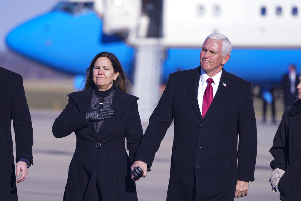 In this Jan. 20, 2021, file photo, former Vice President Mike Pence and his wife Karen walk from the plane to greet supporters after arriving back in his hometown of Columbus, Ind. (AP Photo/Michael Conroy, File)