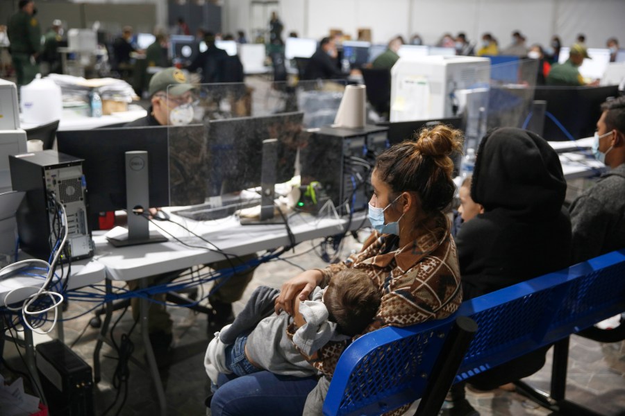 Migrant families wait to be questioned at the preliminary intake area of the Donna Department of Homeland Security holding facility, the main detention center for unaccompanied children in the Rio Grande Valley, in Donna, Texas, on March 30, 2021. (AP Photo/Dario Lopez-Mills, Pool)