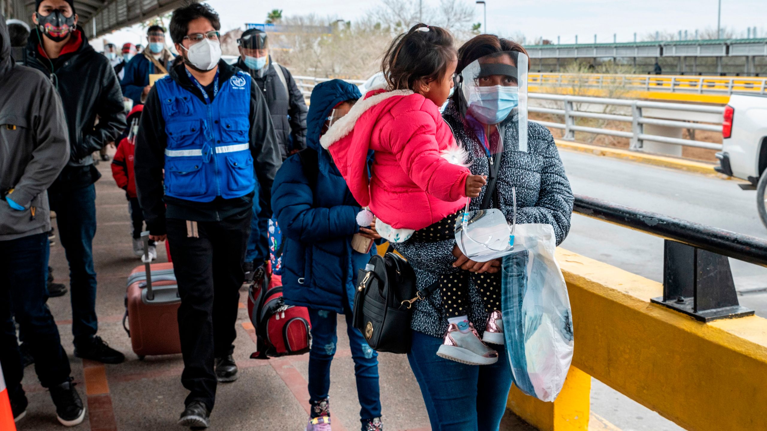 A migrant family approaches the US border on Gateway International Bridge in Brownsville, Texas on March 2, 2021. (SERGIO FLORES/AFP via Getty Images)