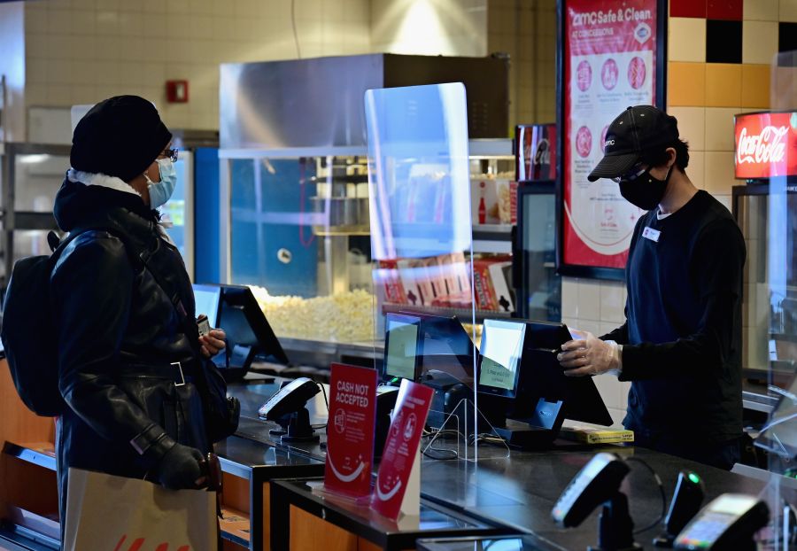 An employee helps a moviegoer with a concessions purchase at AMC Empire 25 off Times Square as New York City's cinemas reopen for the first time in a year following the coronavirus shutdown, on March 5, 2021, in New York City. (ANGELA WEISS/AFP via Getty Images)